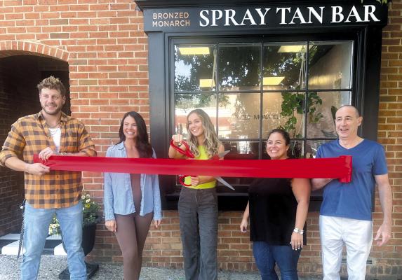 FUN WITHOUT SUN: Brianna Russell (center) happily cuts the ribbon to celebrate the opening of her new tanning salon, Bronzed Monarch. Joining the festivities are (from left to right) her boyfriend Jake Pisani, friend Olivia Fuselli, and Haddonfield Board of Trustee members Tricia Magrann, and Gary Klosner.